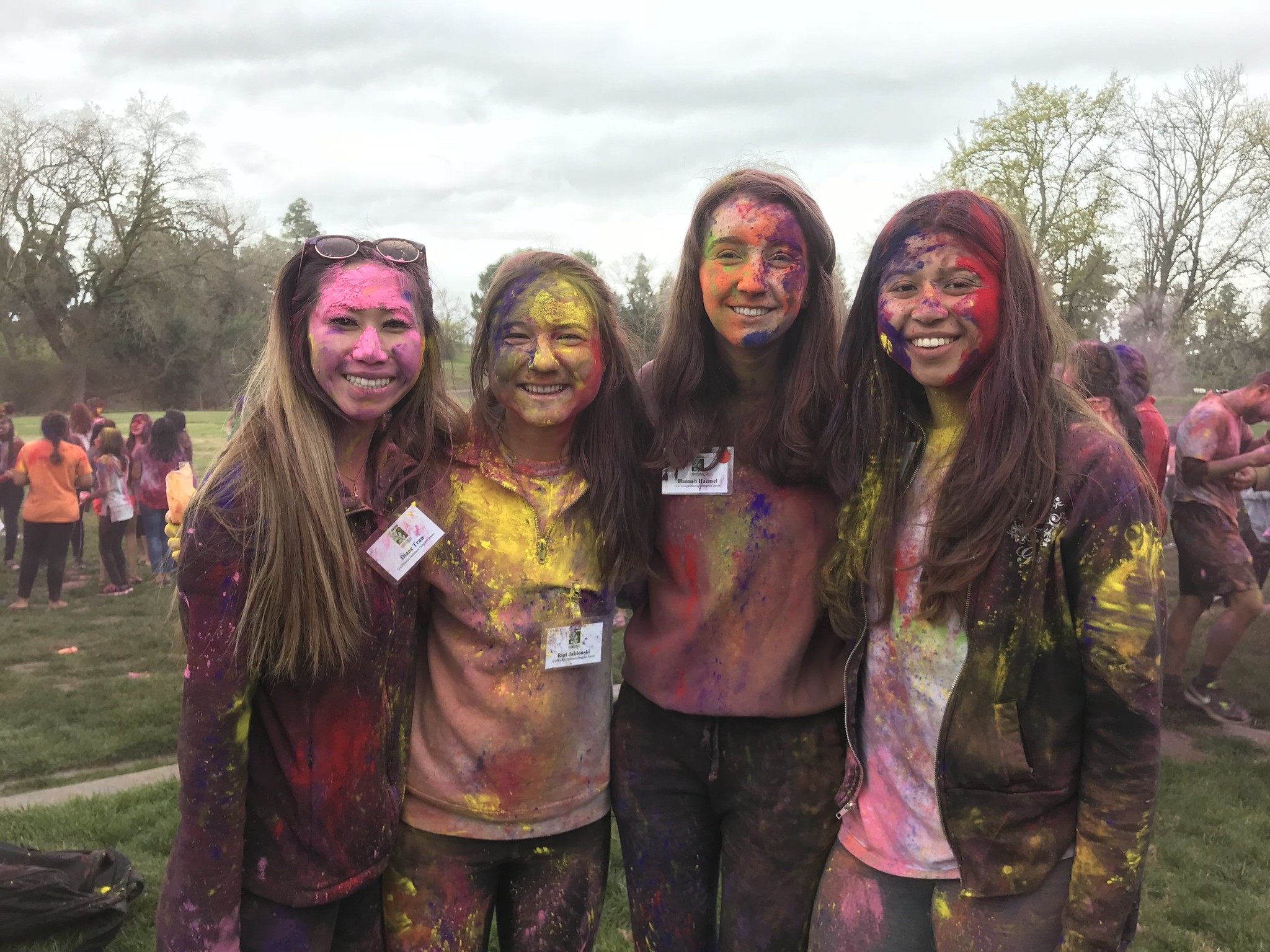 Four students covered in Holi powder posing for a photo