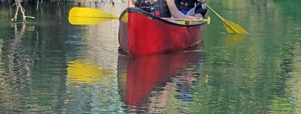 Image of students canoeing down Putah Creek in the Reserve.