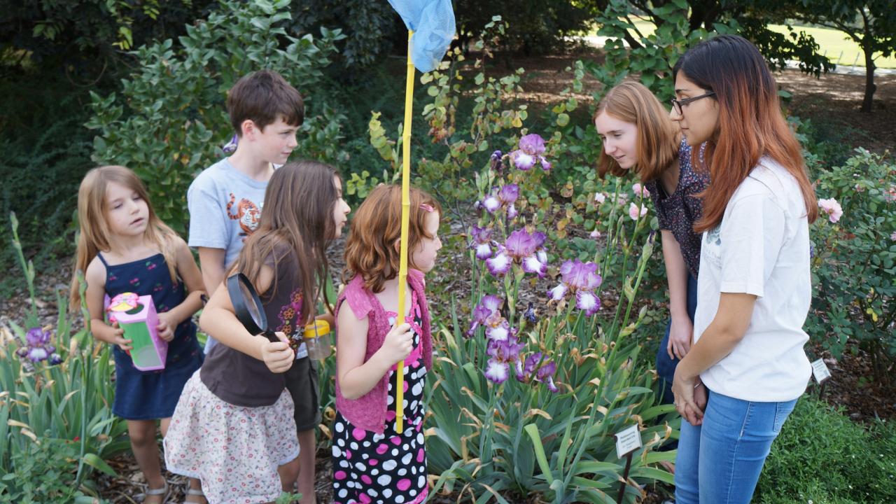 Image of Arboretum Ambassadors with children in the Nature's Gallery Court garden.