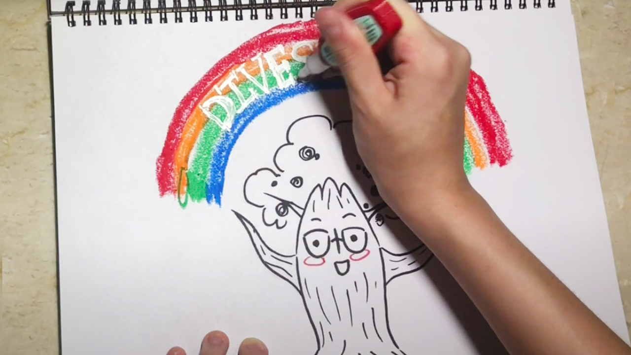 Image of a hand drawing an oak tree with a rainbow above it.