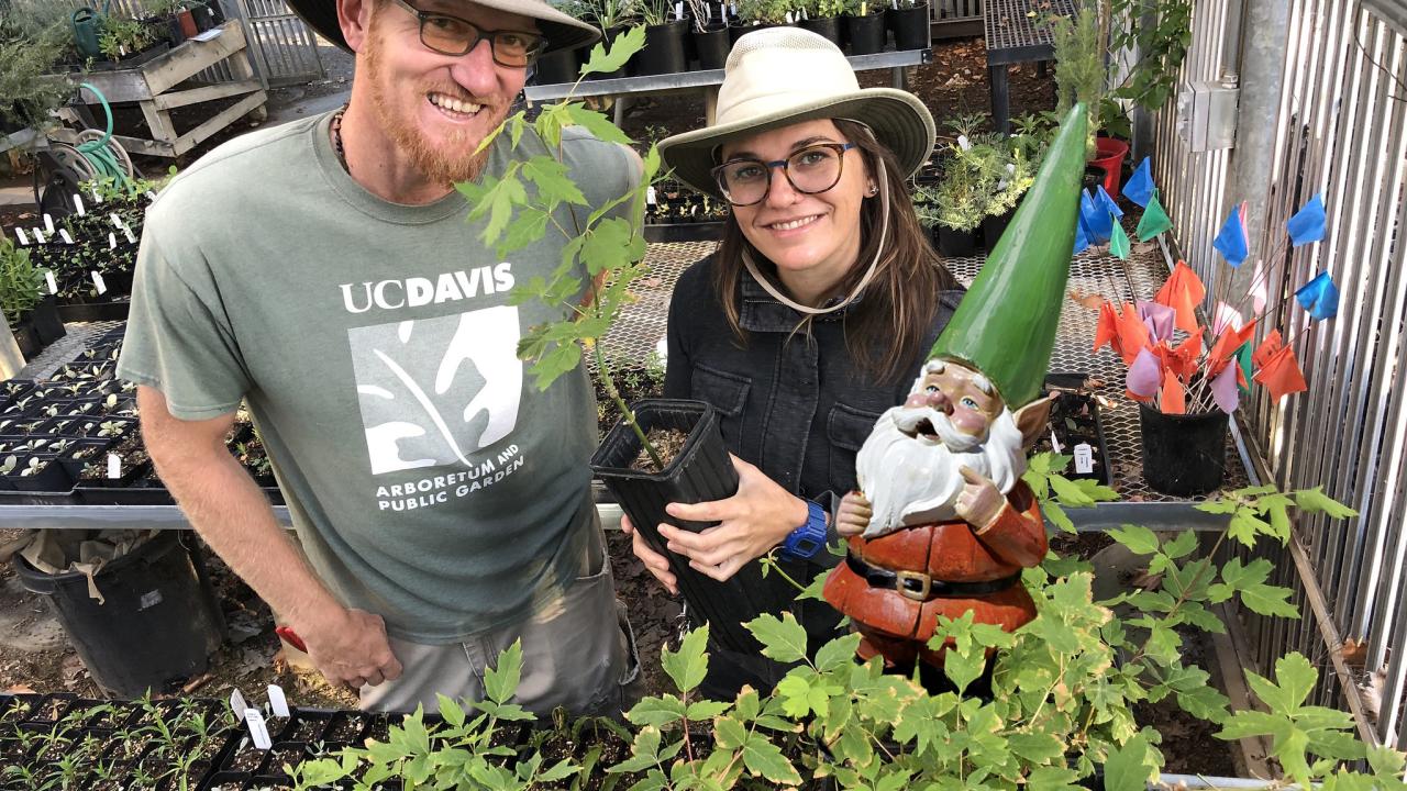 Image of Taylor Lewis, nursery manager and Abbey Hart, special projects manager with a gnome! Yes, that's right!