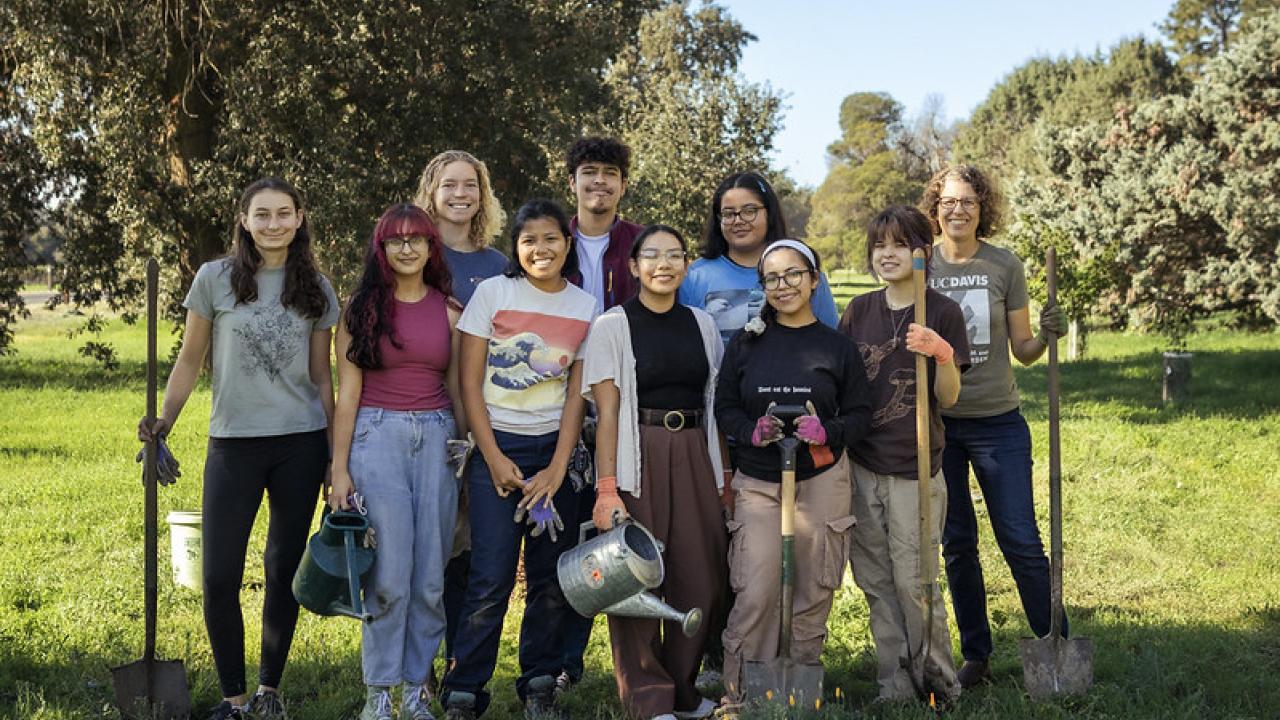 group of interns holding tools after a tree planting