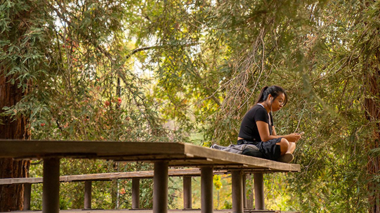 girl listening to music in the Arboretum 