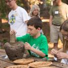 Image of young man learning how to grind acorns.