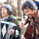 Folk musicians play instruments and laugh