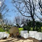 Outdoor sound-bath setup with white crystal singing bowls, brass gong, and mallets on mat