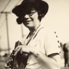Black and white image of woman holding a camera from the early 1900s.