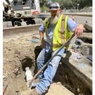 Person in a small trench working on irrigation